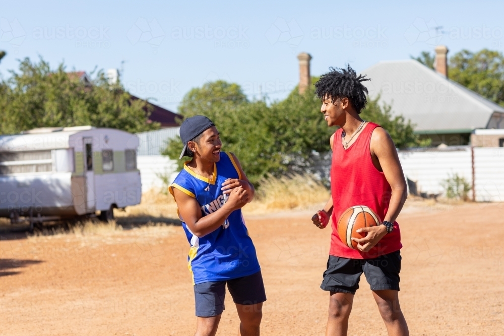 two mates with basketball in vacant lot - Australian Stock Image