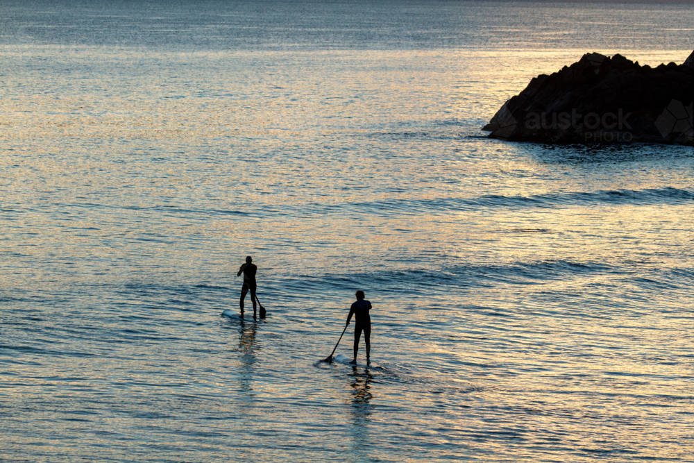Image of Two mature men paddleboard SUP near Norries Head at Cabarita ...