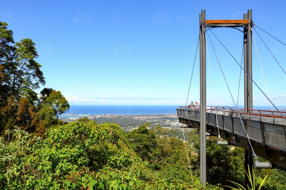 Two mature people standing on Forest Sky Pier overlooking Coffs Harbour on the NSW coast - Australian Stock Image