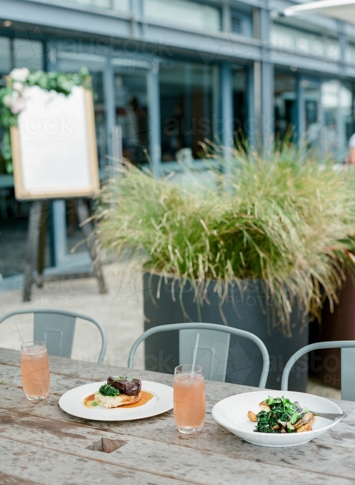 Two meals on outdoor table at a restaurant - Australian Stock Image