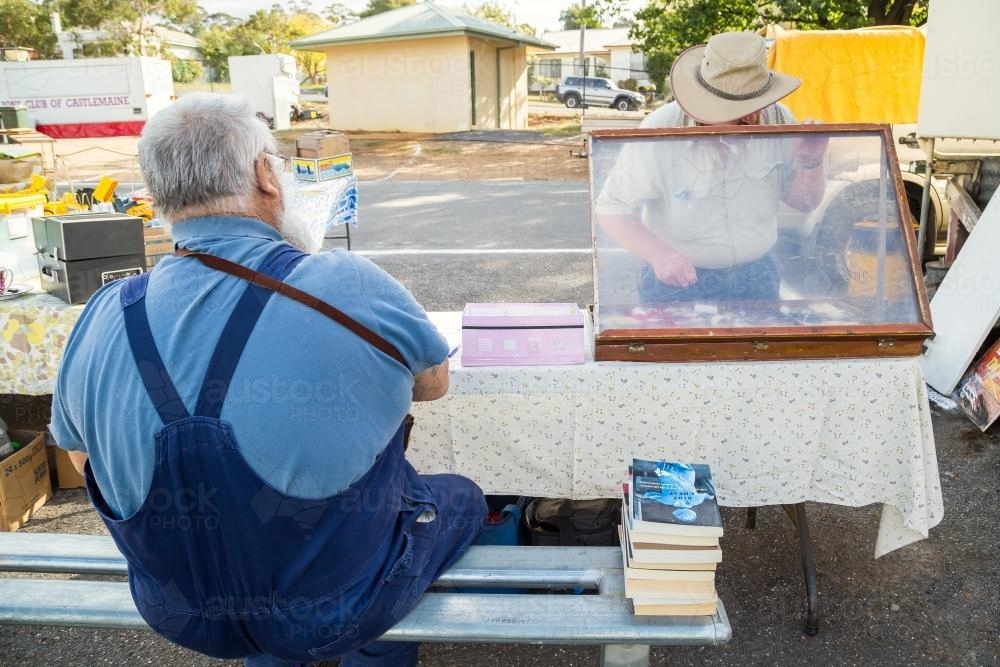 Two men buying and selling at a swap meet - Australian Stock Image