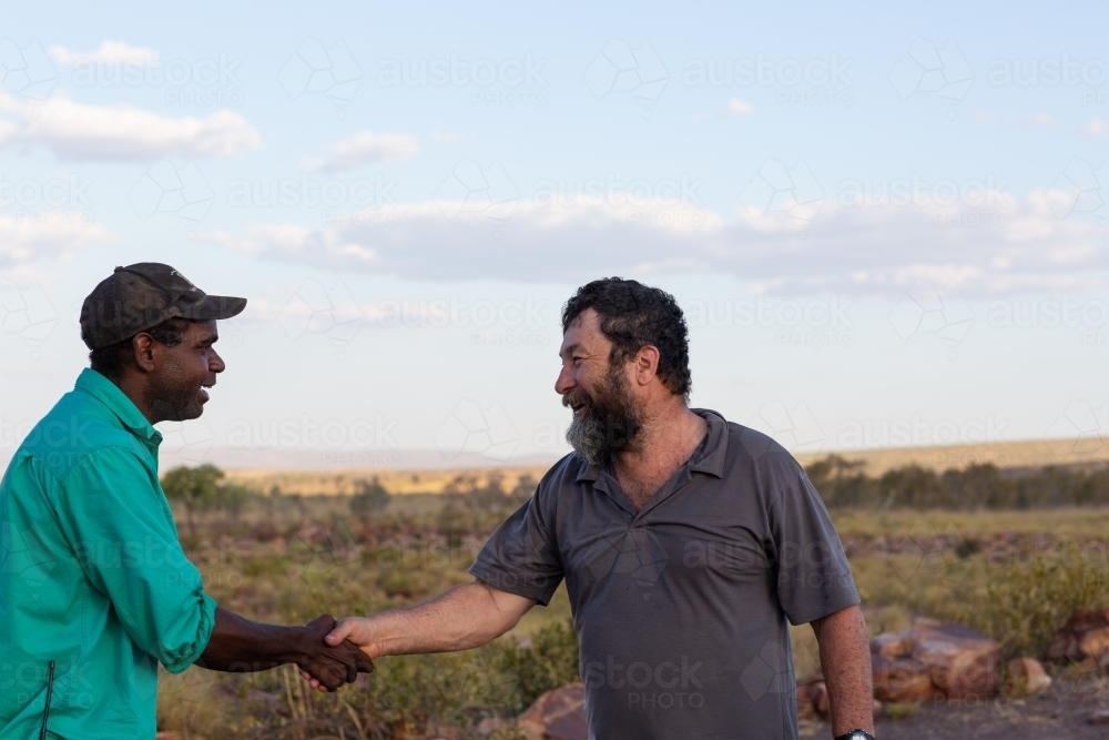 Two men shaking hands in the outback - Australian Stock Image