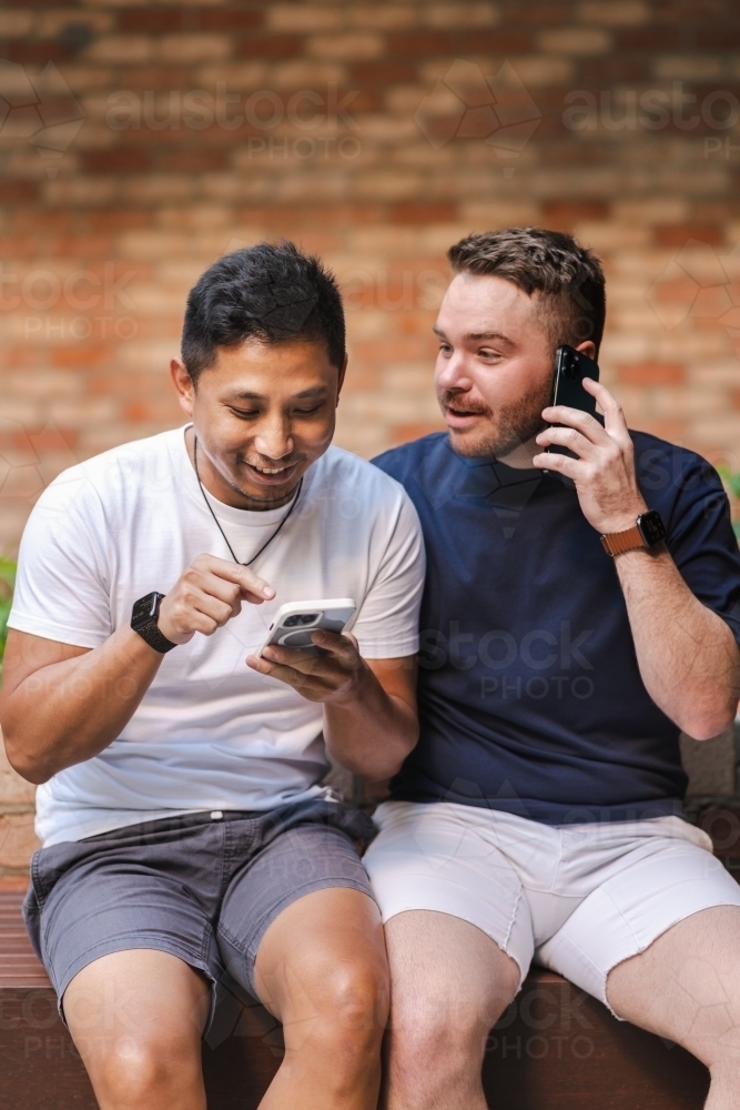 two men using mobile phone - Australian Stock Image