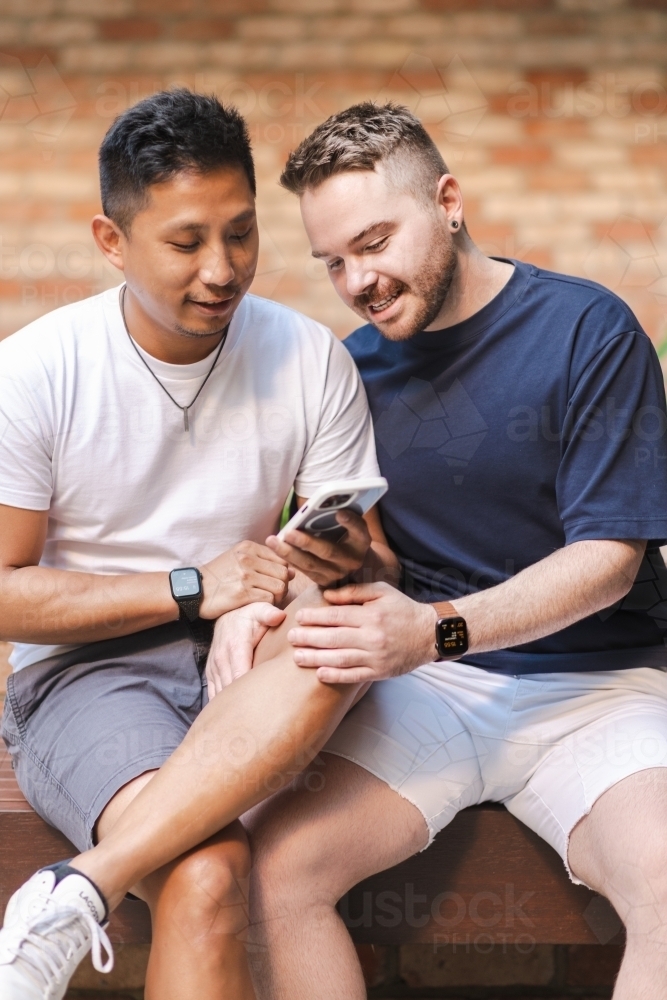 two men using phone - Australian Stock Image