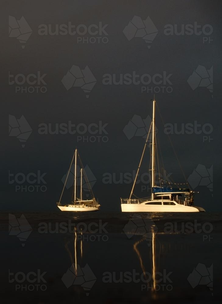 Two Moored Yachts Illuminated by the Setting Sun - Australian Stock Image