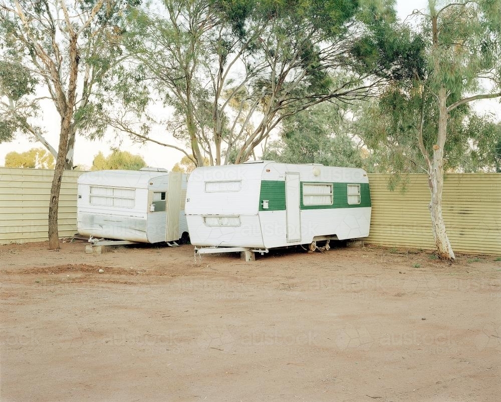 Two old caravans parked in dusty, remote caravan park - Australian Stock Image