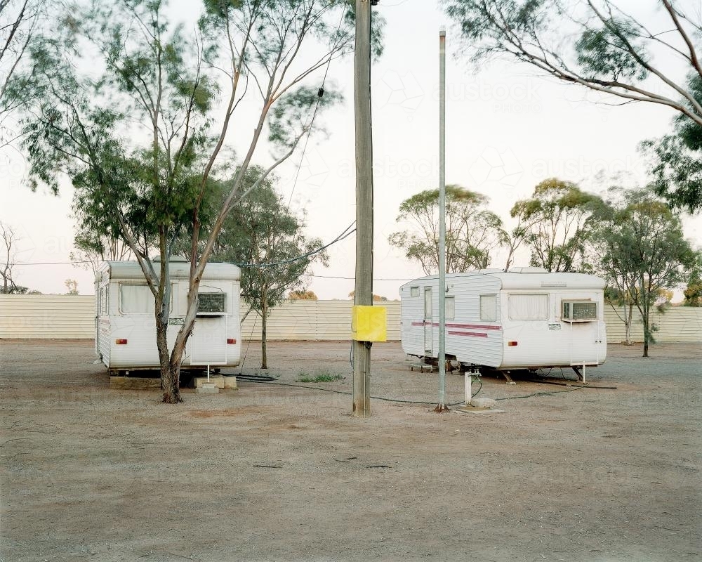 Two old caravans parked in dusty, remote caravan park - Australian Stock Image