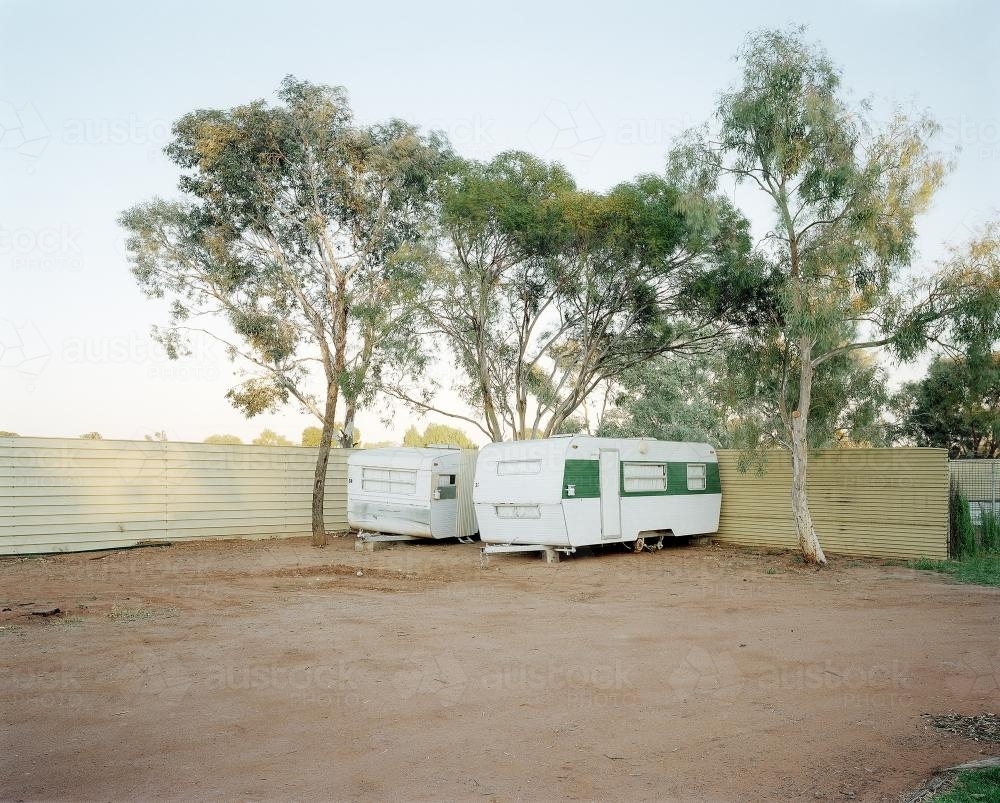 Two old caravans parked in dusty, remote caravan park - Australian Stock Image