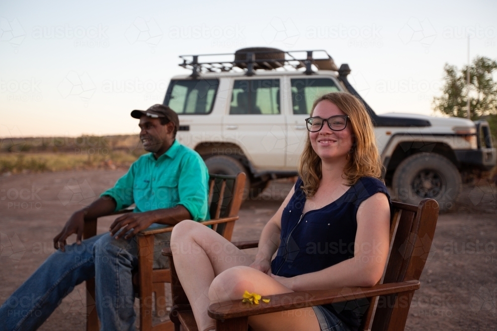 Two people sitting outback  with 4WD in background - Australian Stock Image