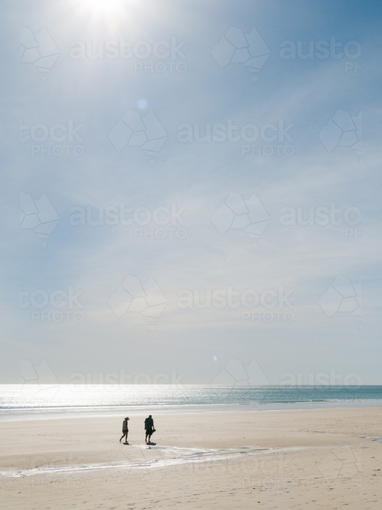 Two People Walk on Secluded Beach - Australian Stock Image