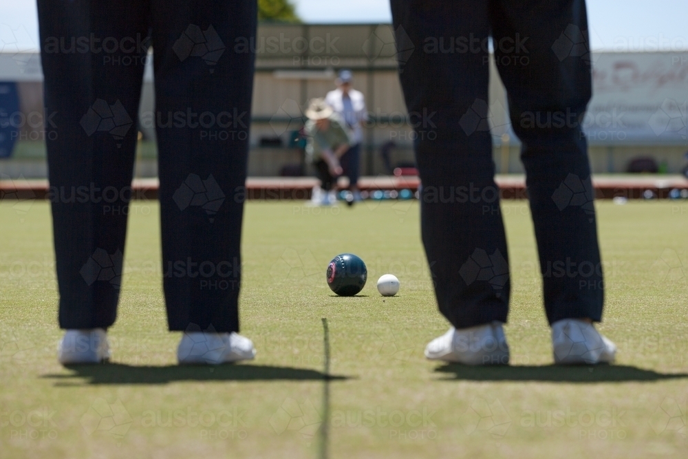 Two people watching another person bowling - Australian Stock Image
