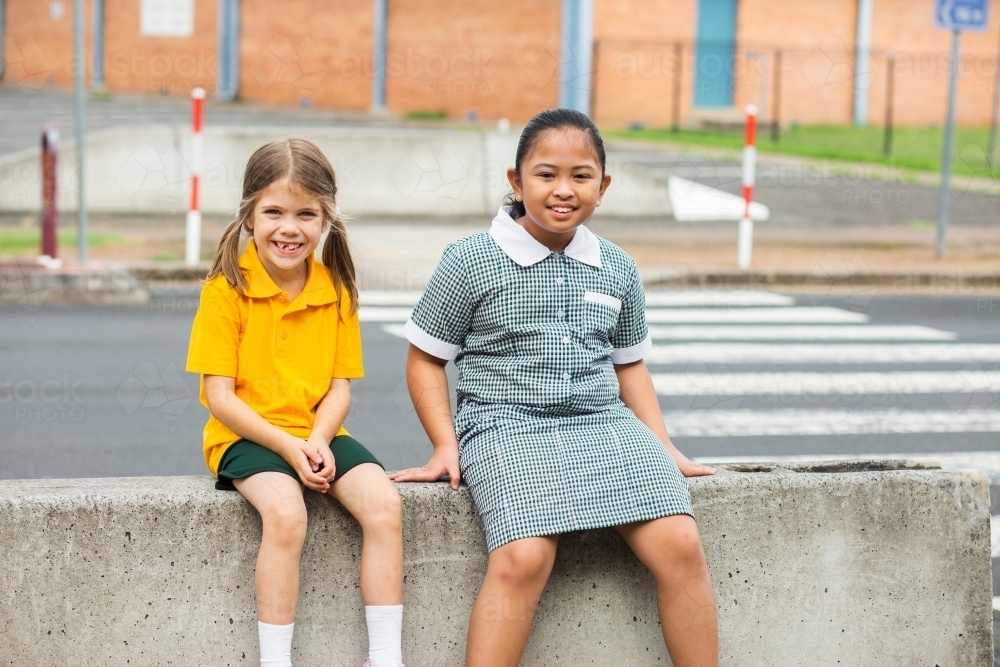 Two public school friends sitting together before school - Australian Stock Image
