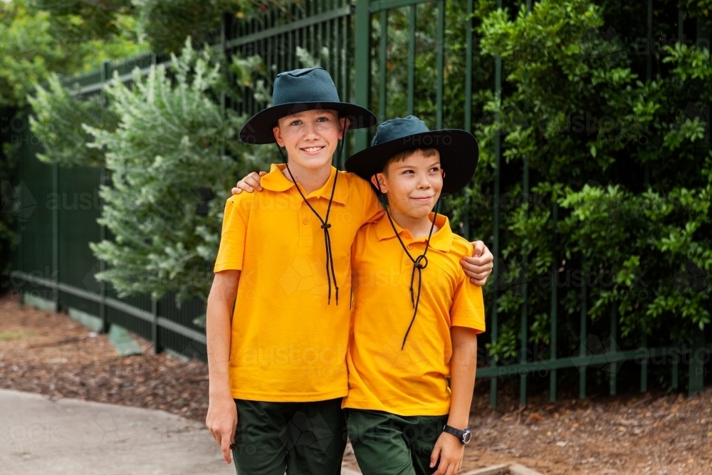 Image of Two school boys with arms around each other - Austockphoto