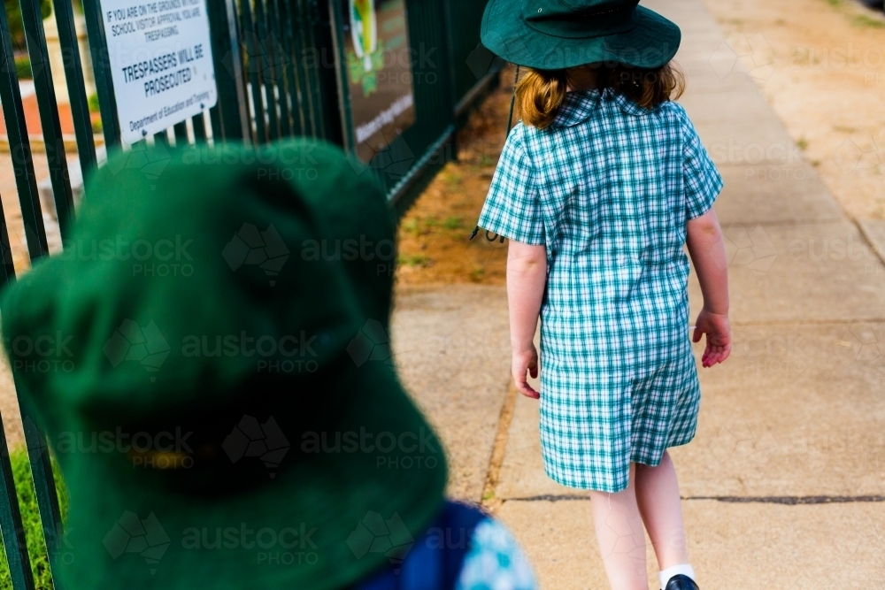 Two school girls walking to school shot from behind - Australian Stock Image