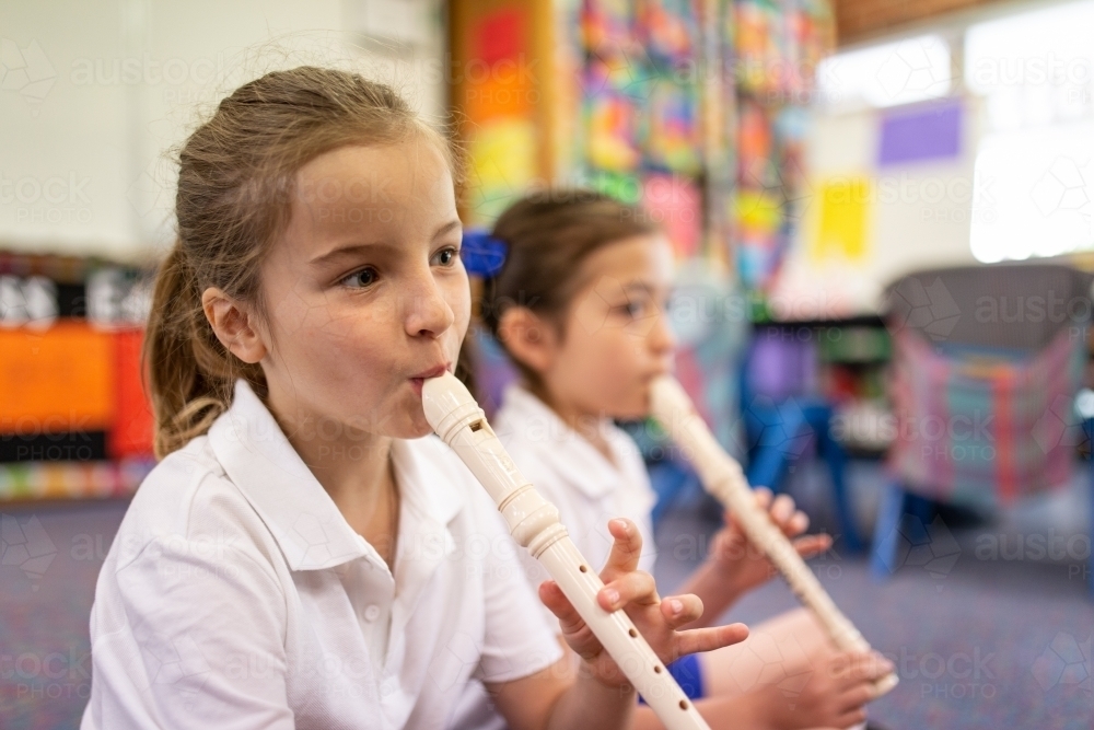 Two Schoolgirls Playing Recorder in Classroom - Australian Stock Image