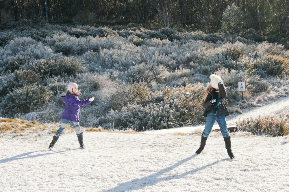 two sisters having a snowball fight - Australian Stock Image