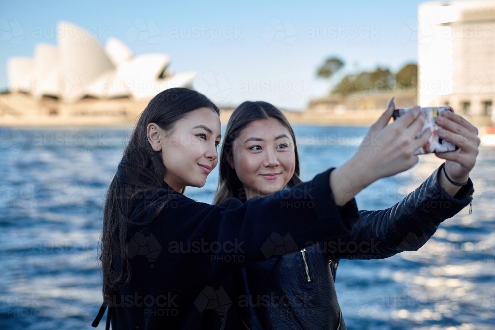 Two sisters spending time together harbourside taking selfie - Australian Stock Image