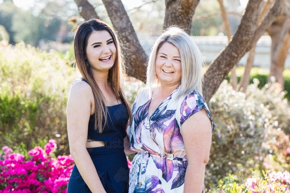 Two sisters standing together laughing - Australian Stock Image