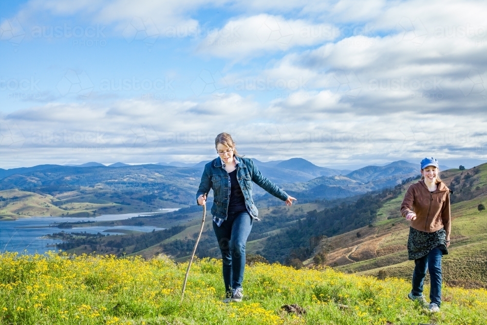 Two sisters walking up a hill  in the mountains - Australian Stock Image