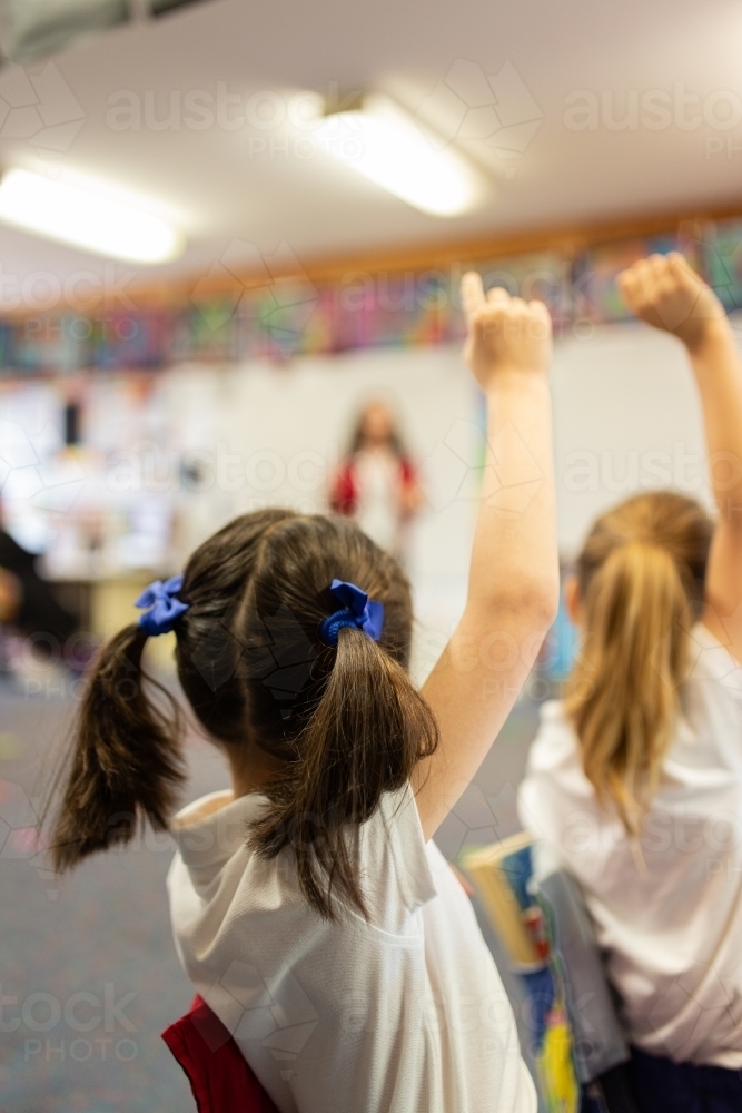Two Students with their Hands Up in Classroom - Australian Stock Image