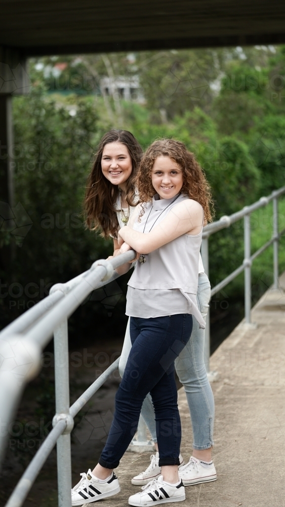 Two teenage girls standing by railing - Australian Stock Image