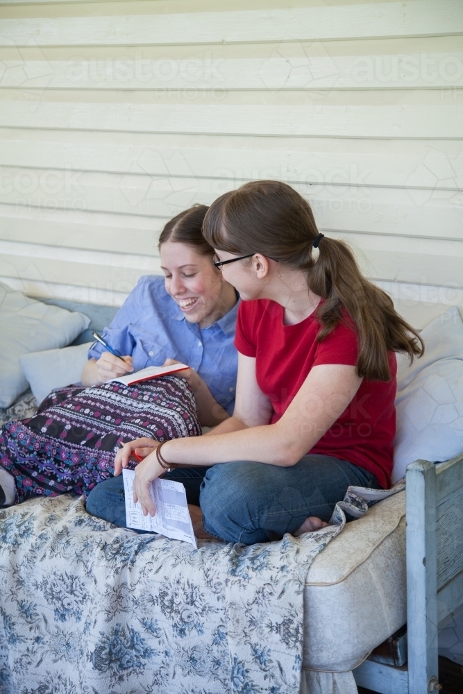 Two teenage girls talking together on the verandah - Australian Stock Image