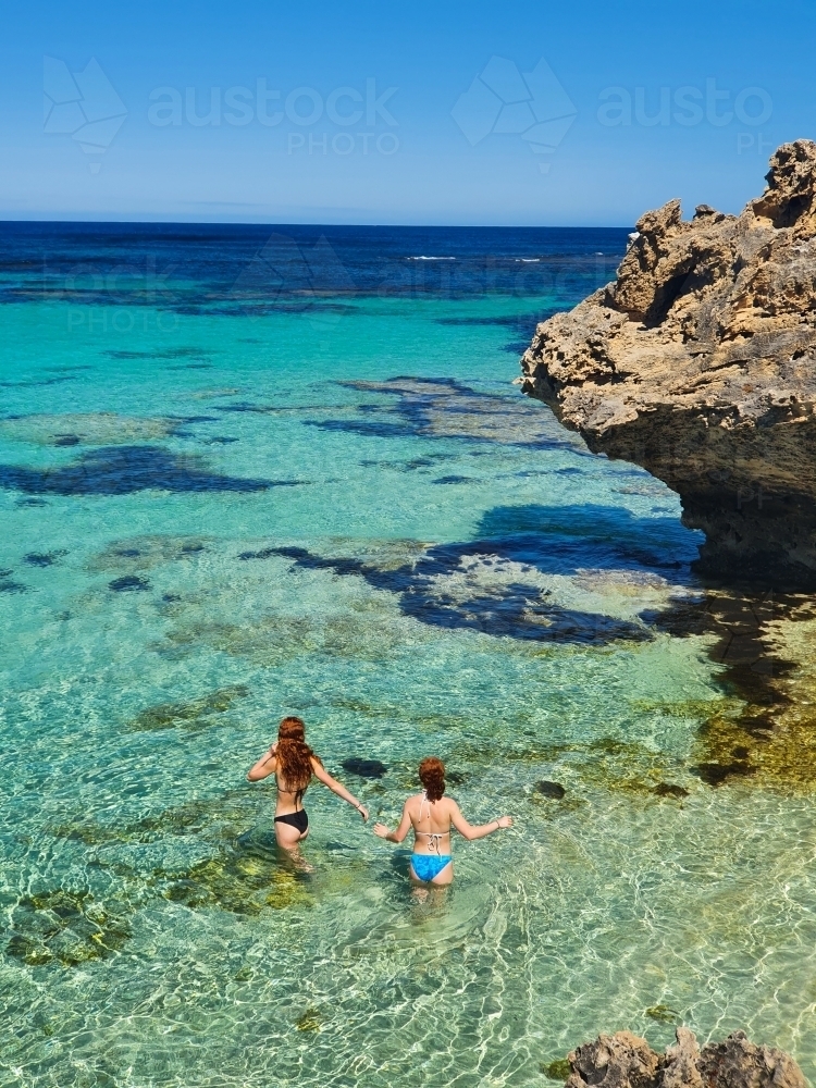 Two teenage girls wading in the ocean - Australian Stock Image