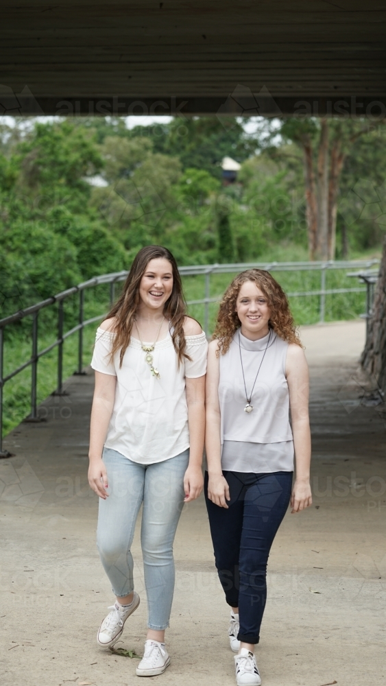 Two teenage girls walking on a paved pathway - Australian Stock Image