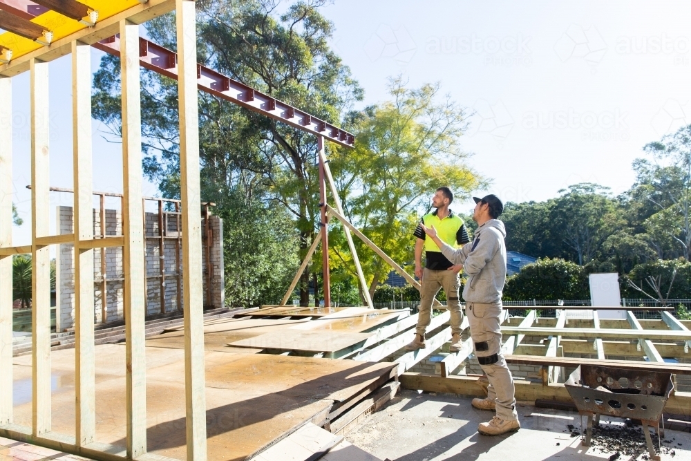 Two trades working together to problem solve at a house renovation site - Australian Stock Image