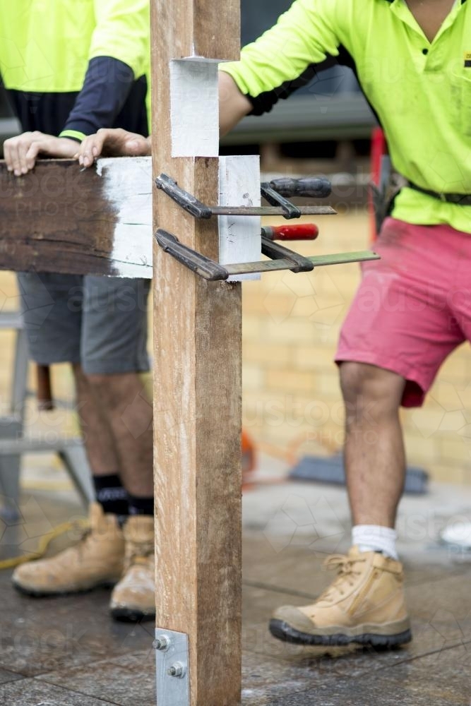 Two tradesmen fixing a wooden beam. - Australian Stock Image