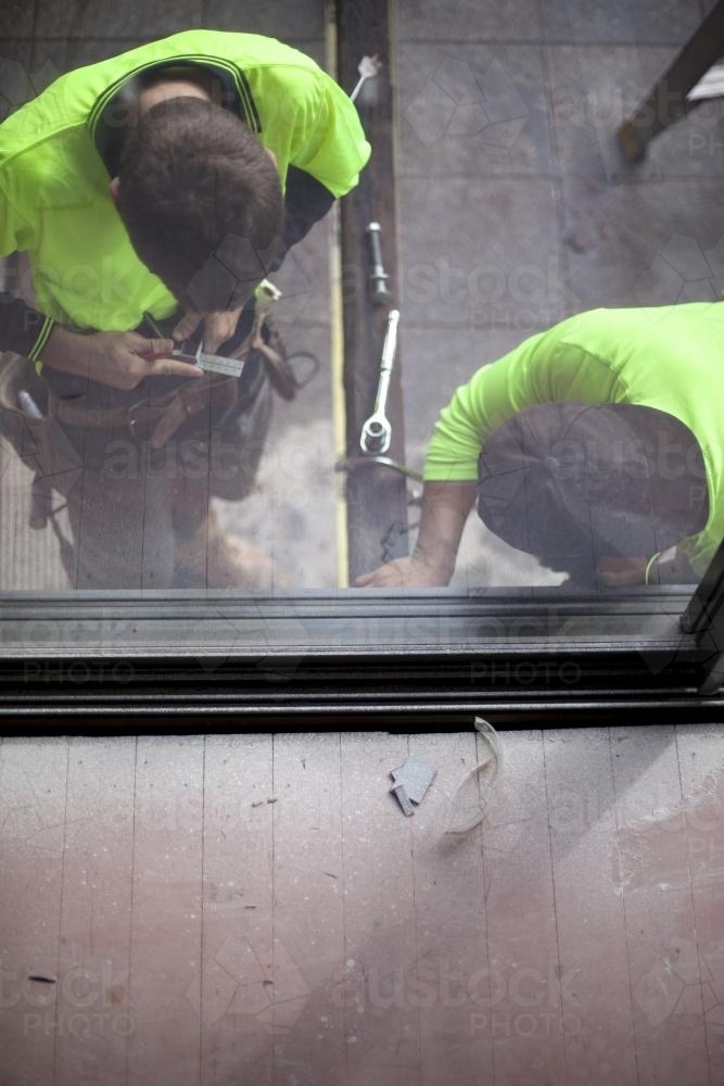 Two tradesmen work on home renovations. - Australian Stock Image
