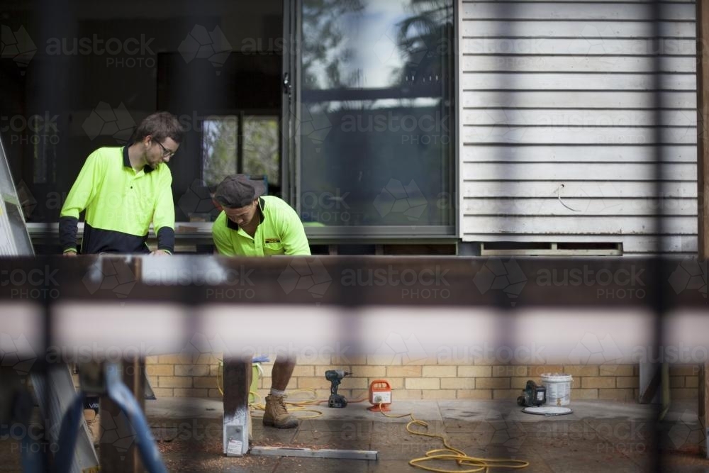 Two tradesmen work on home renovations. - Australian Stock Image