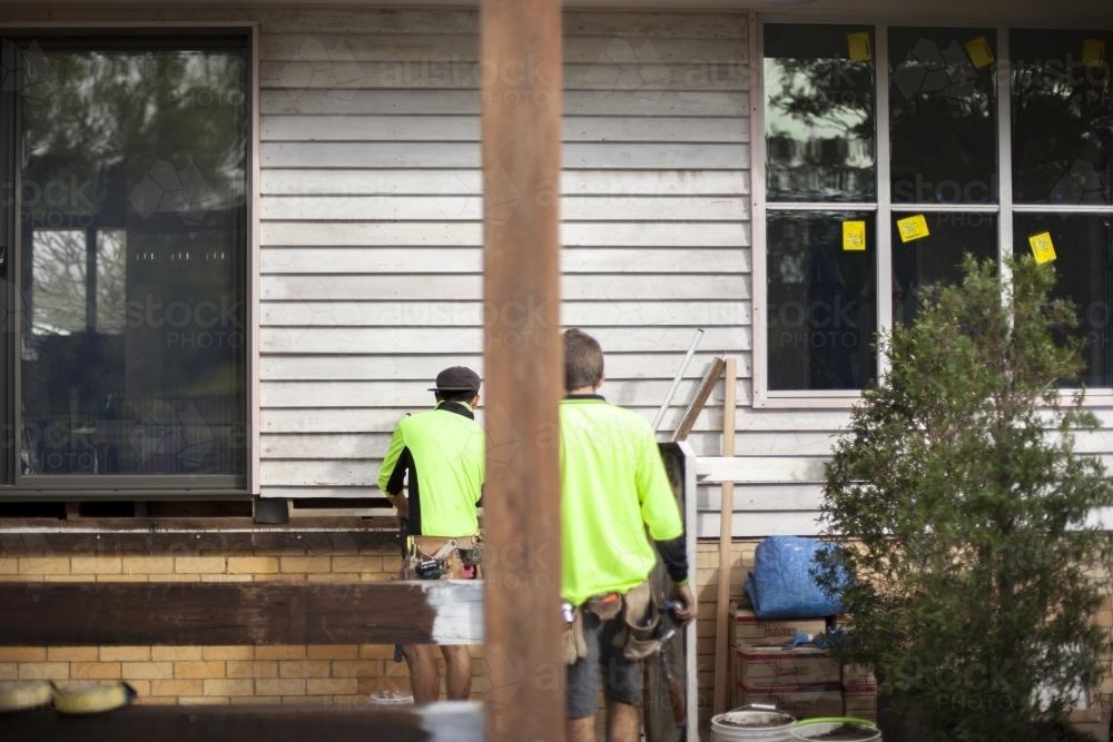 Two tradesmen work on home renovations. - Australian Stock Image