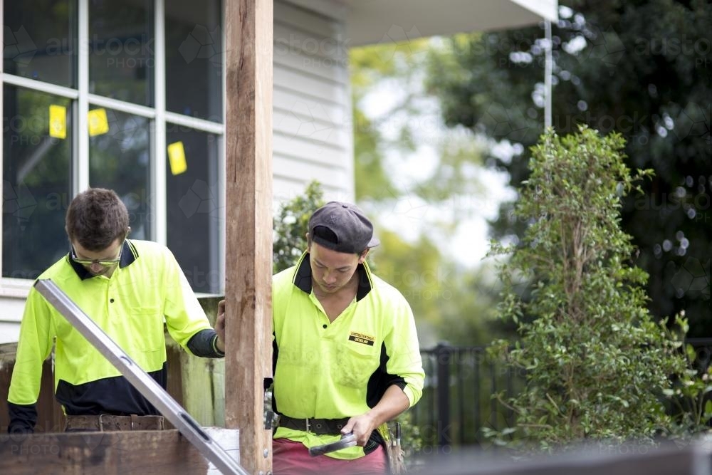 Two tradesmen work on home renovations. - Australian Stock Image