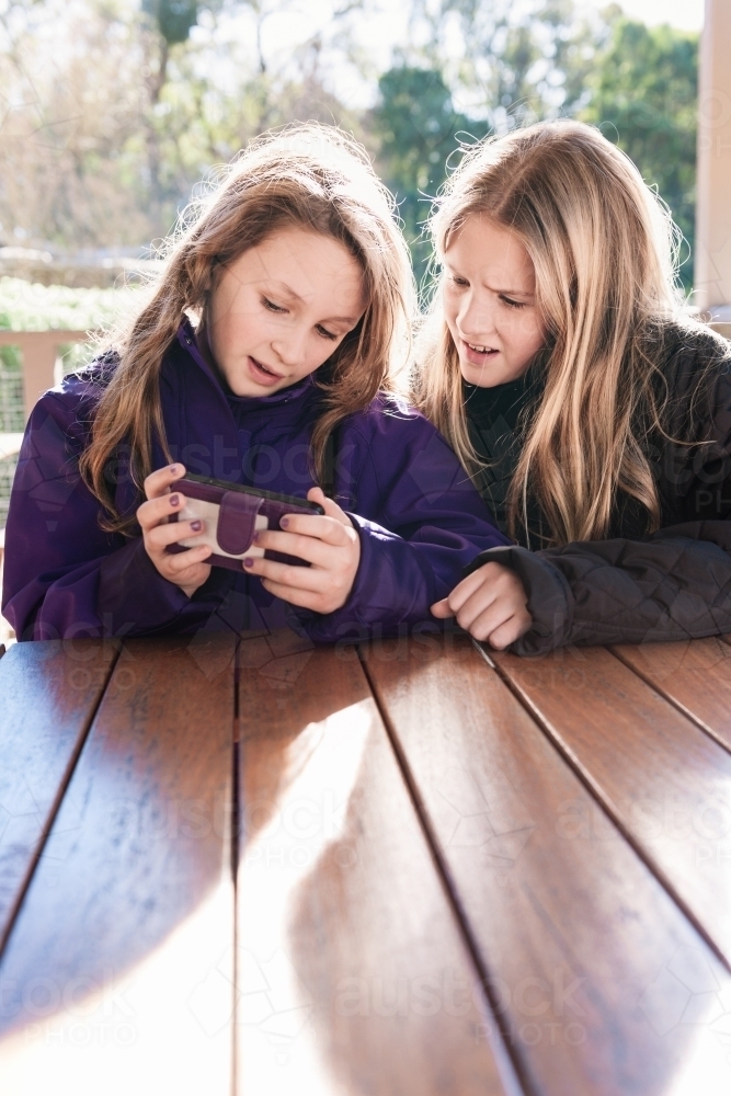 two tween girls looking at a phone - Australian Stock Image