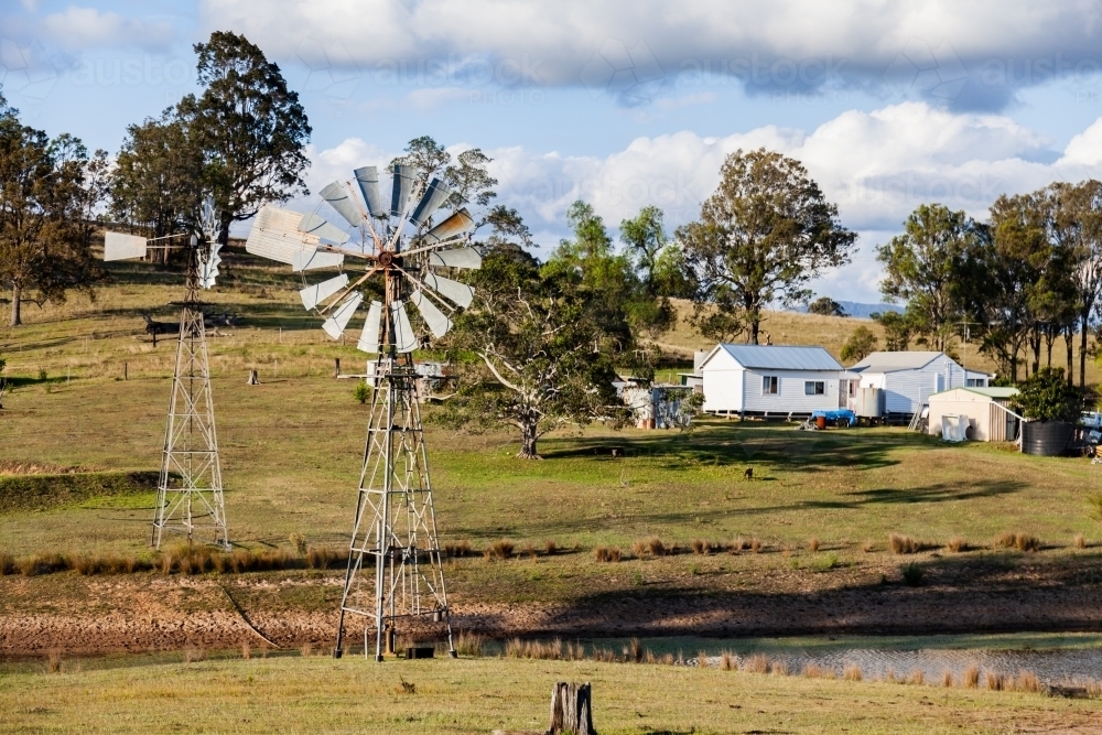 Two windmills and country house on farm - Australian Stock Image