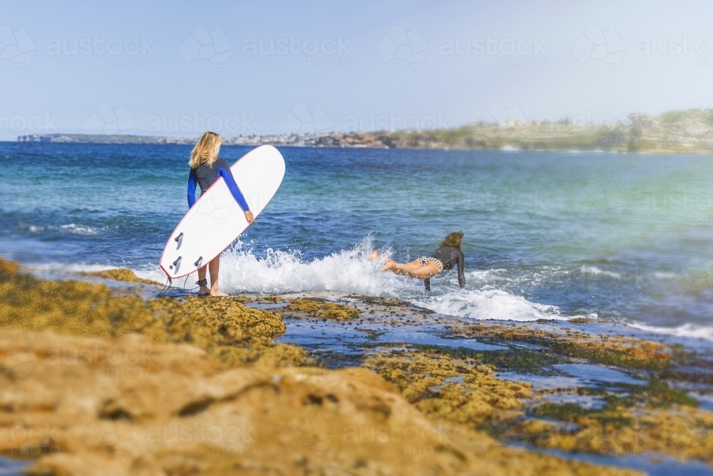 Two women going surfing - Australian Stock Image