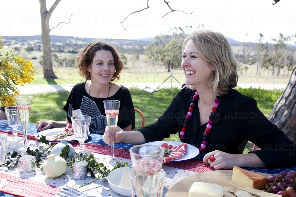 Two women sitting at a table outside on Christmas day - Australian Stock Image