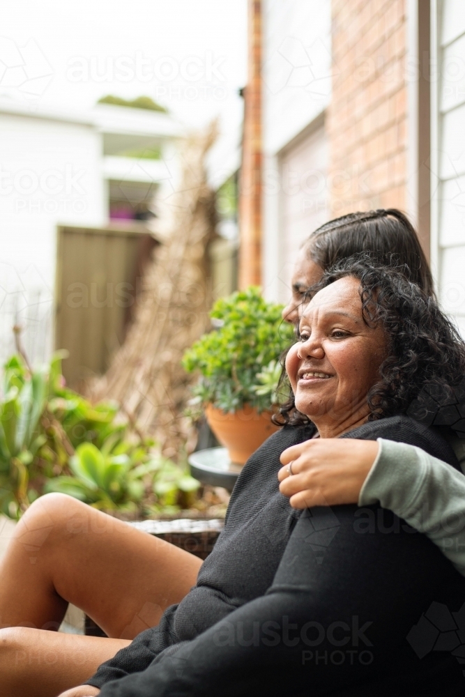 Image of two women sitting outside in the garden - Austockphoto