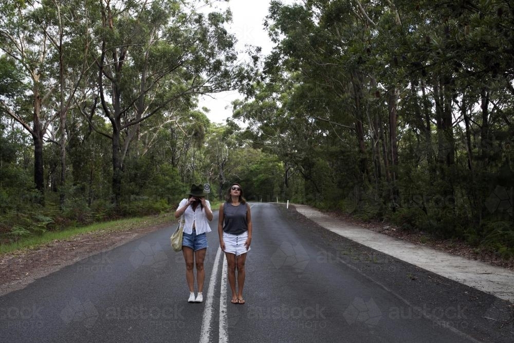 Two women standing in the middle of the road - Australian Stock Image