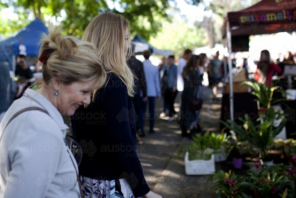 Two women walking through an outdoor market - Australian Stock Image