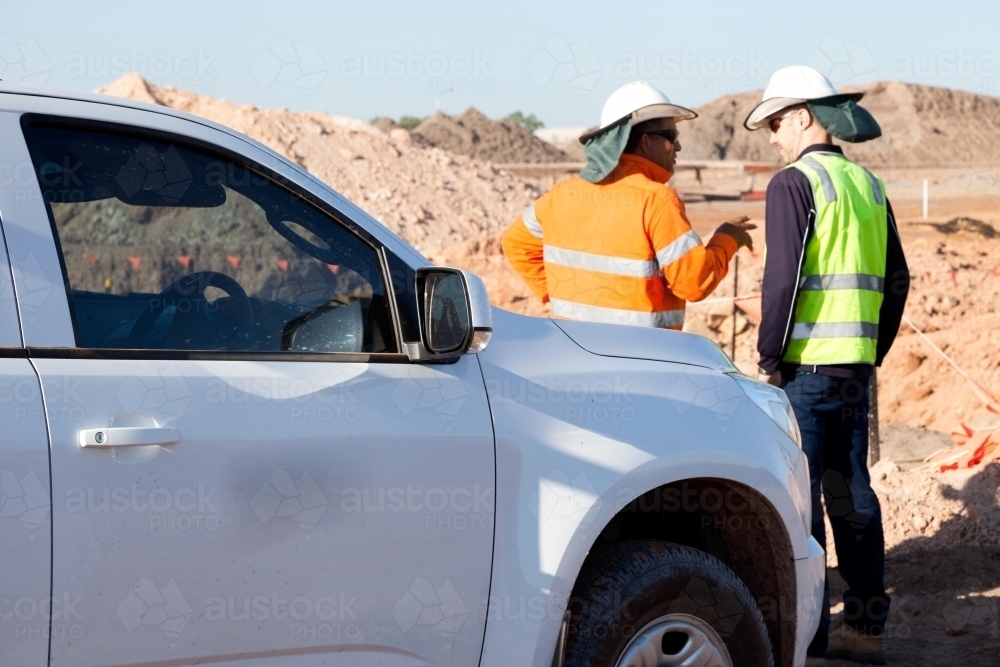 Two workers in discussion on an industrial worksite - Australian Stock Image
