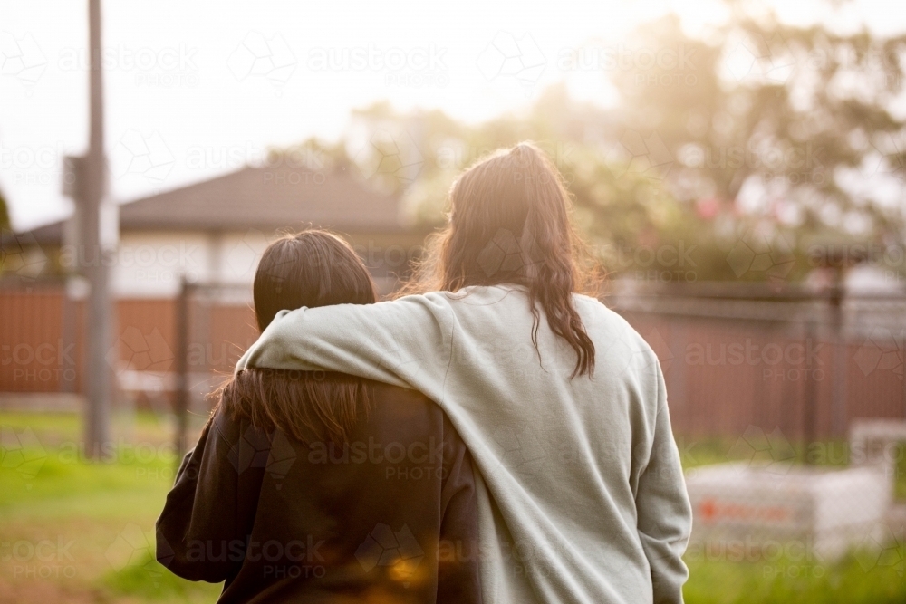 Image of Two young Aboriginal women walking together arms around each ...