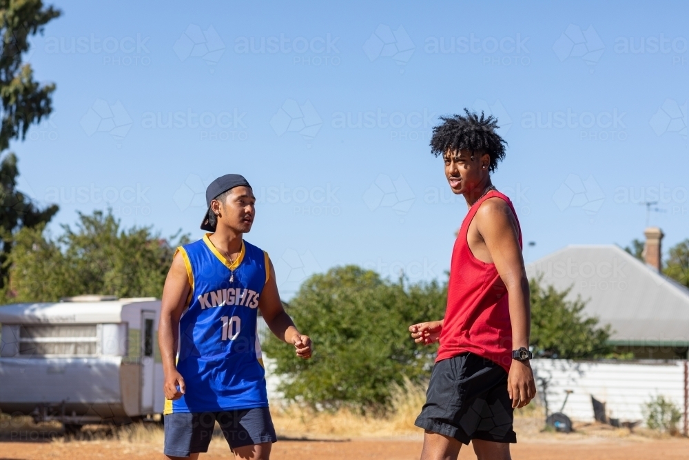 two young blokes facing each other in poor neighbourhood - Australian Stock Image