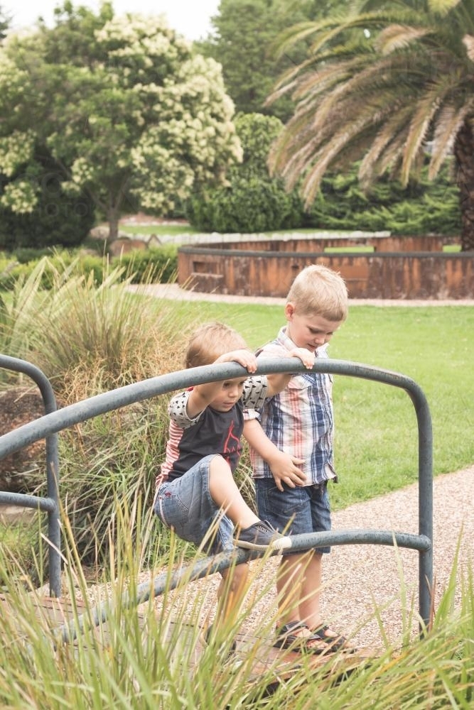 Two young boys standing on a bridge in a park - Australian Stock Image