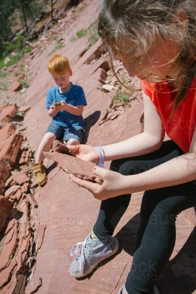 Two young children go looking for fossils in the rocks - Australian Stock Image