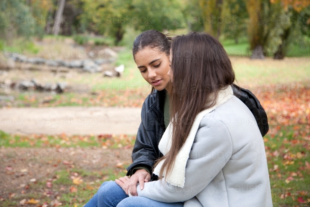 Two young females sitting in an outdoor setting - Australian Stock Image