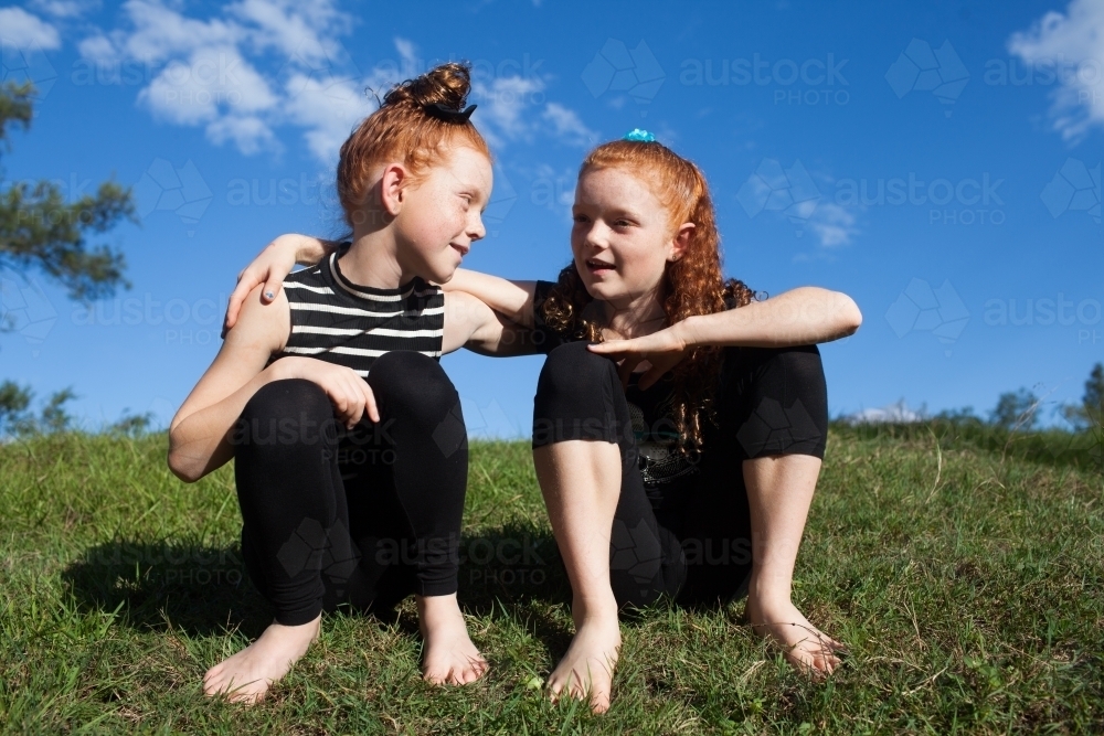 Two young girls sitting outside - Australian Stock Image