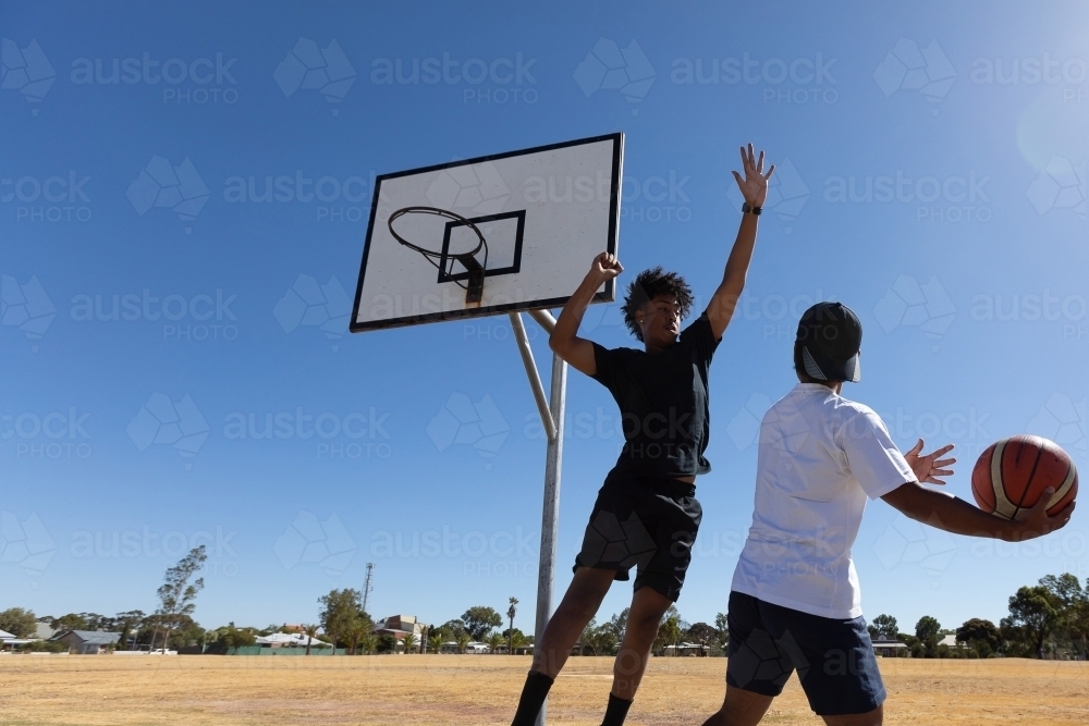 two young guys playing one-on-one basketball - Australian Stock Image