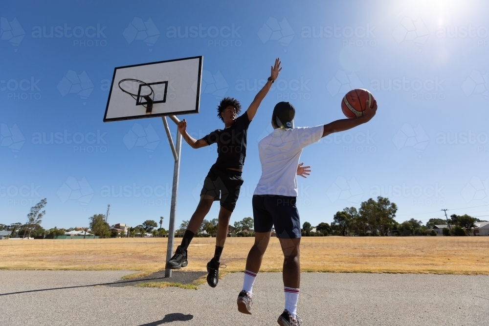 two young guys playing one-on-one basketball - Australian Stock Image